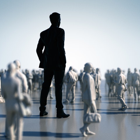 one very large person in black in the middle of lots of small people in white