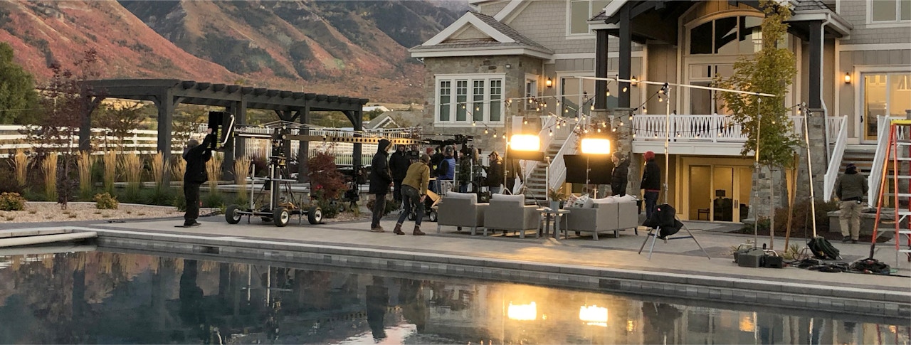 a behind the scenes shot of a group of people on a Belgard patio with pool