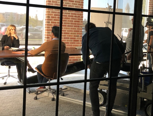 a behind the scenes shot of 2 people in a conference room