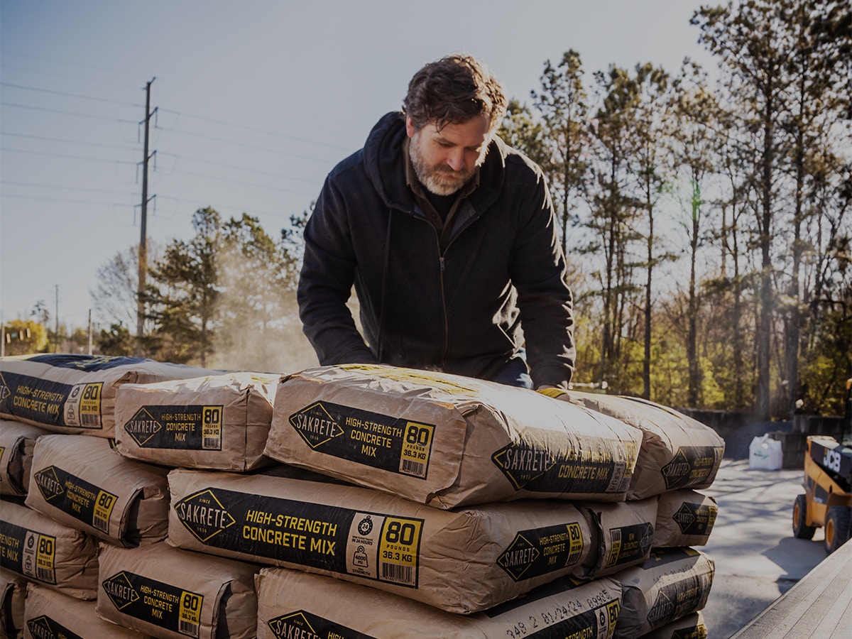 man unloading pallet of Sakrete concrete mix