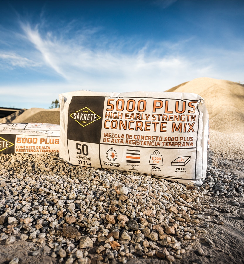bag of Sakrete 5000 plus high early strength concrete mix sitting on a pile of stone