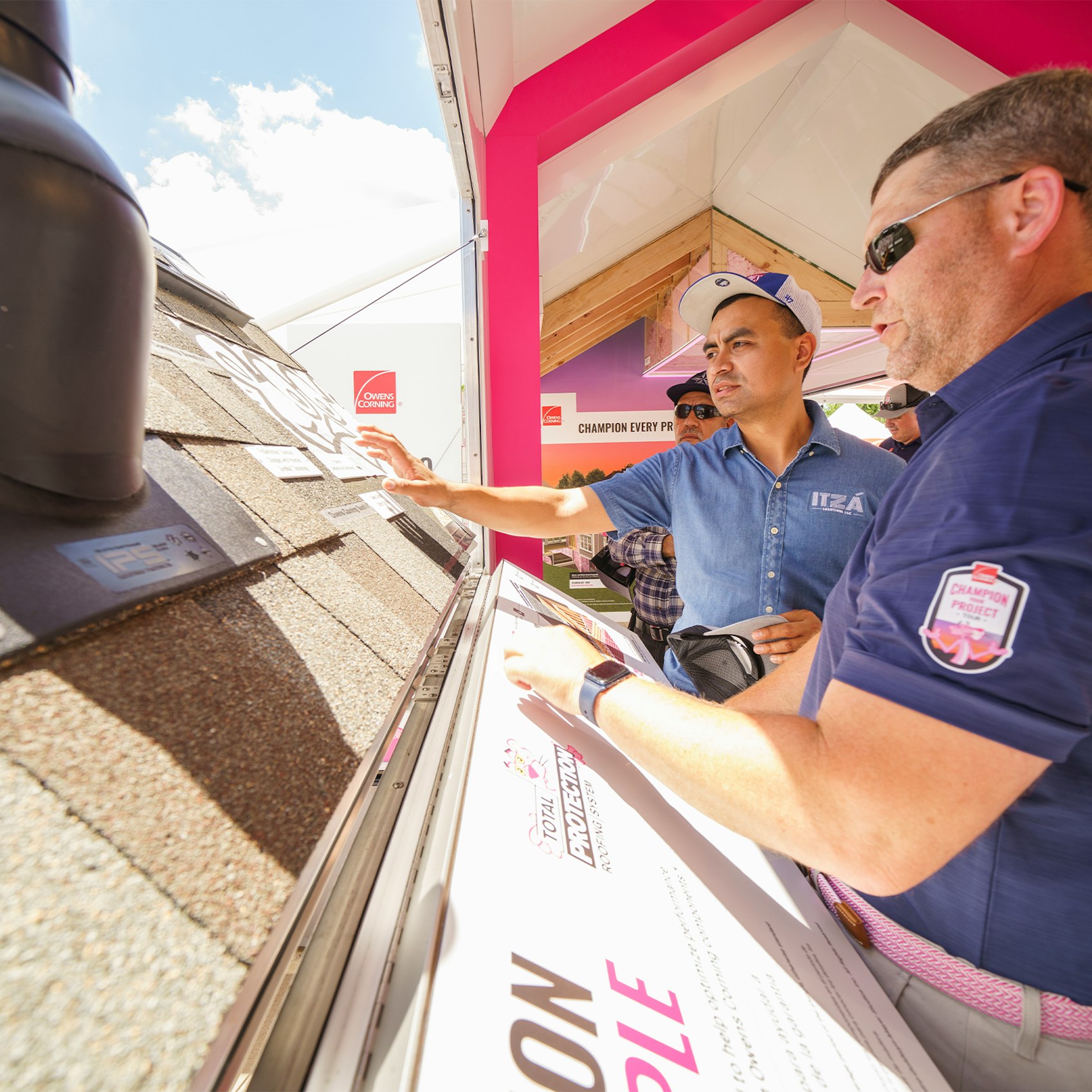 two men in a discussion over an Owens Corning shingle board
