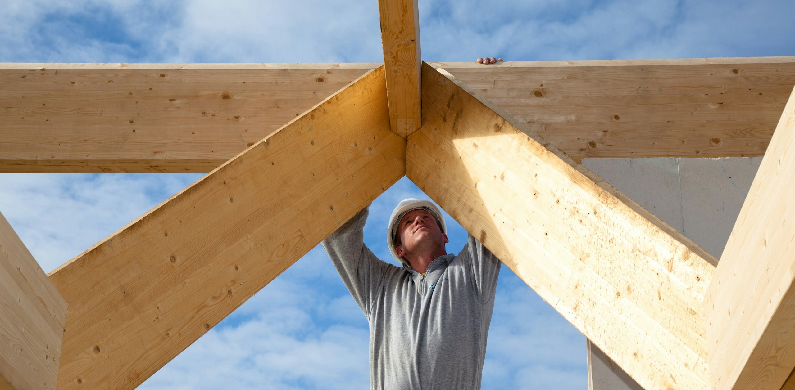 builder working on framing the roof of a building