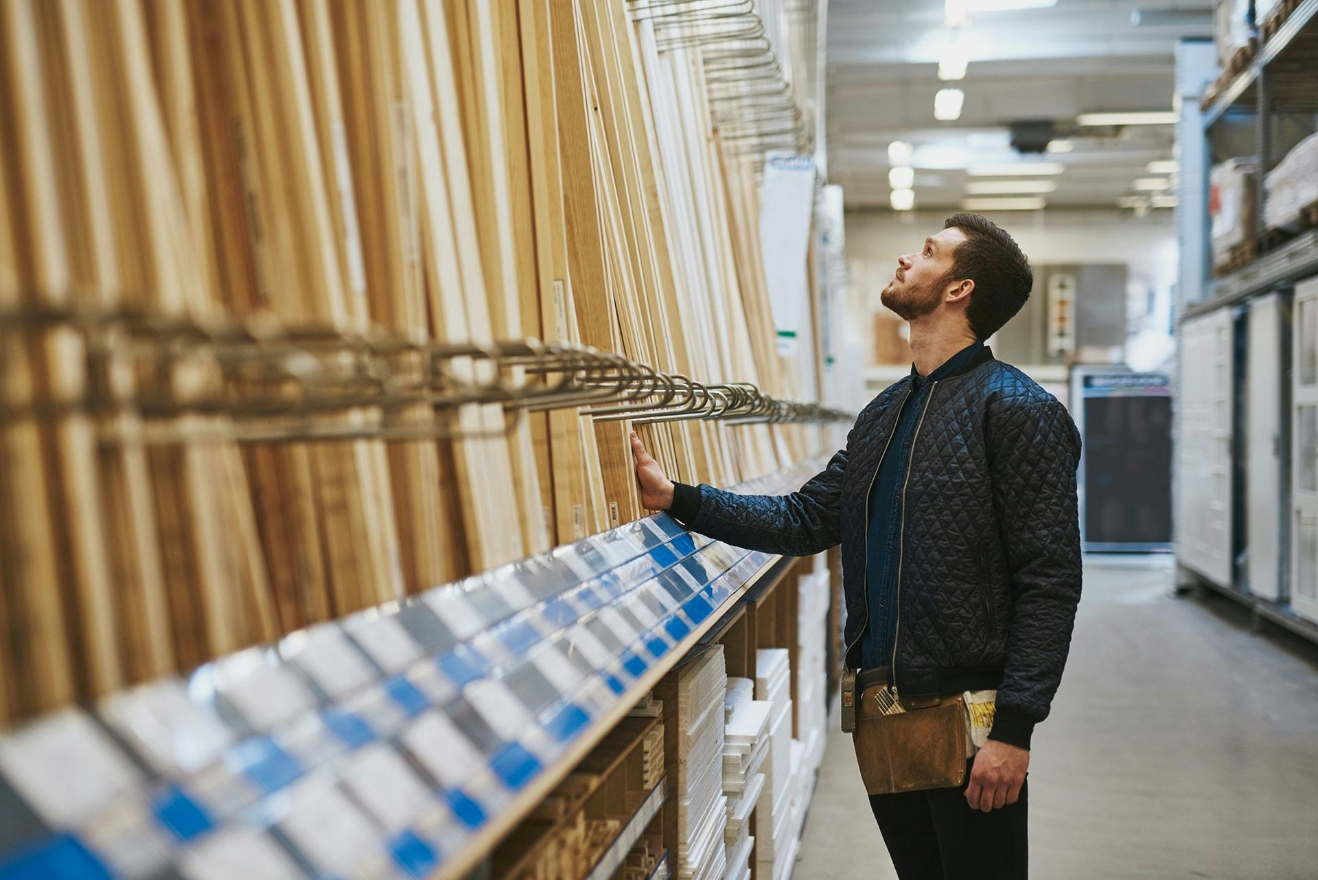 man shopping for lumber at a hardware store