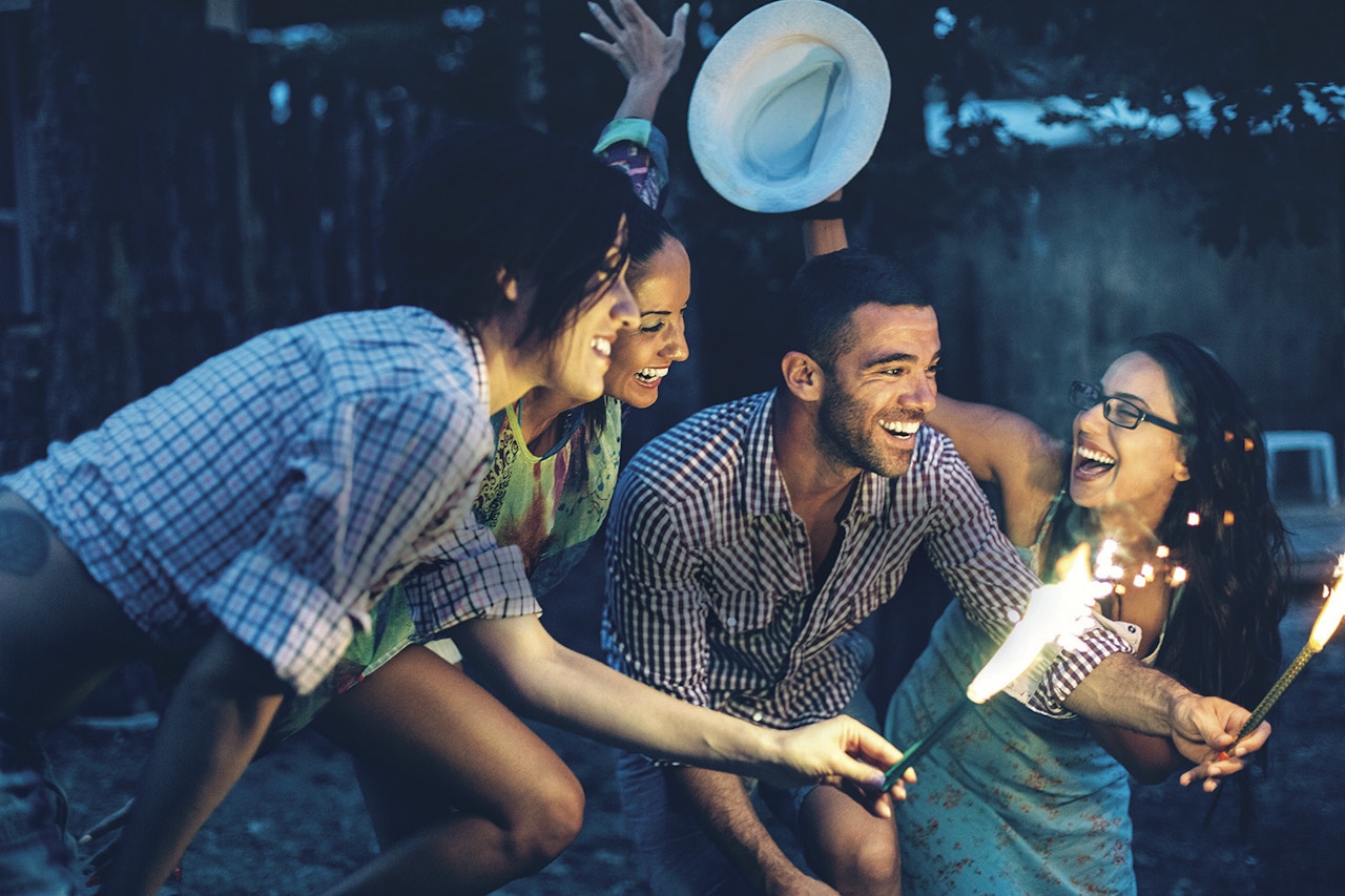 a group of smiling people with sparlers