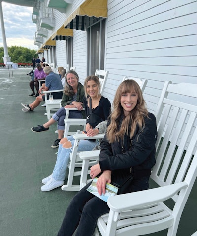 Interrupt employees sitting in rocking chairs on front porch of Machinac Island hotel