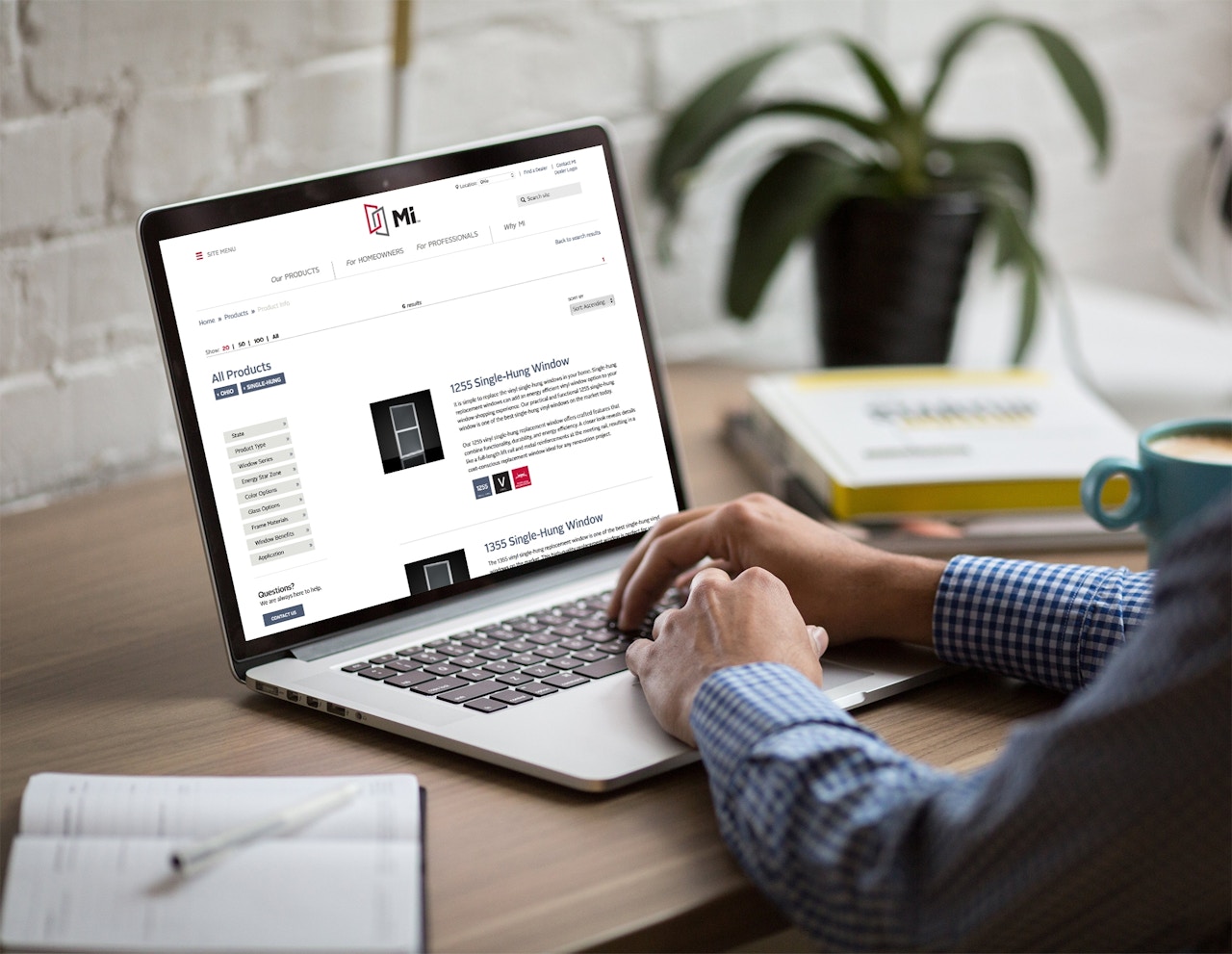 person sitting at desk with laptop displaying Miter website