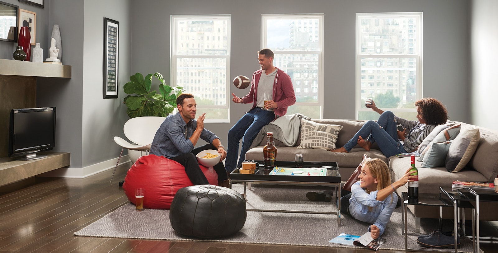 group of people sitting in a living room with beer and wine