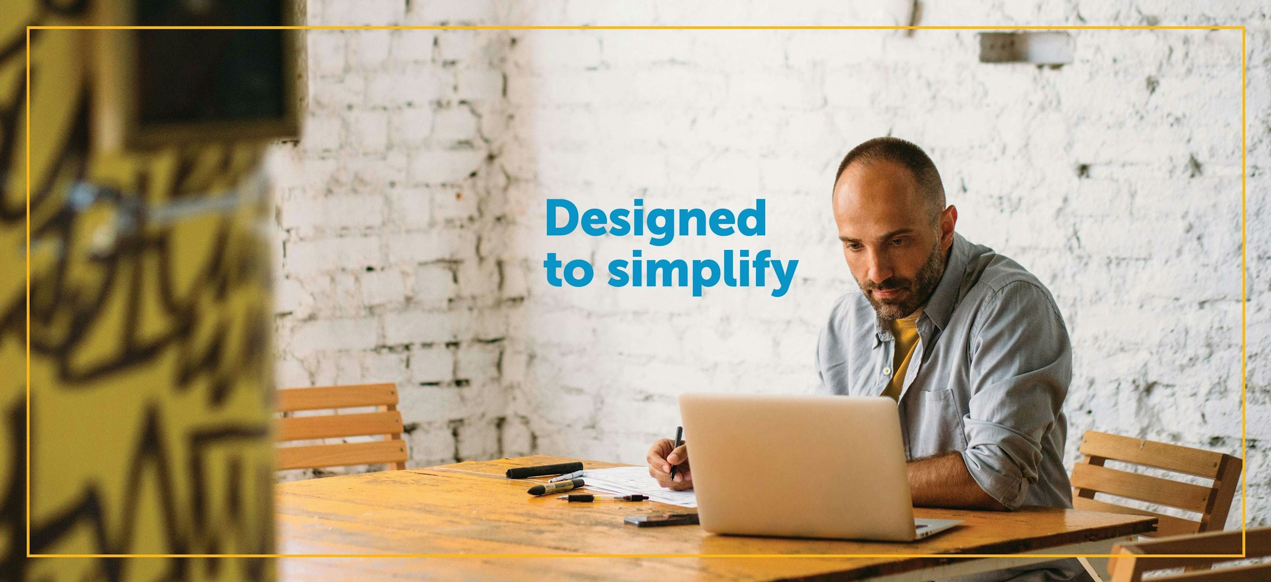 man sitting at table working on laptop