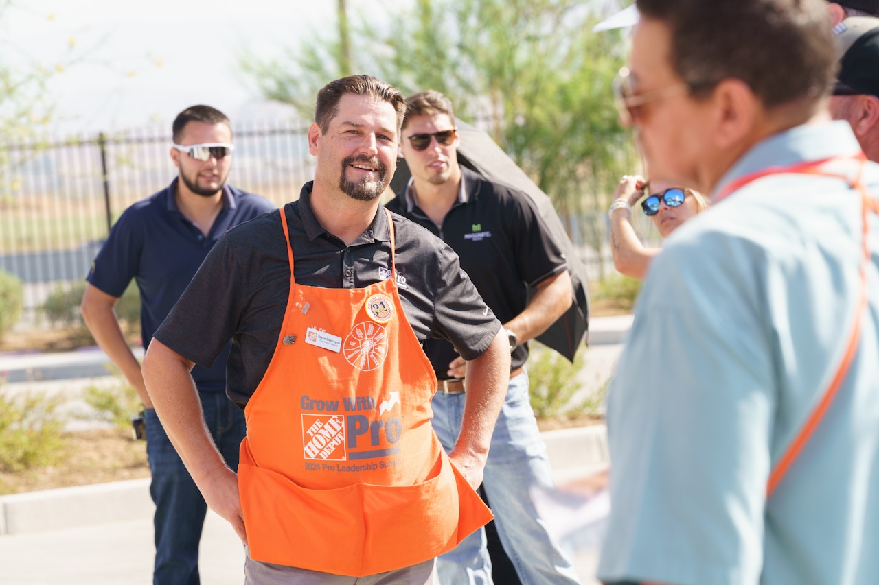 Home Depot employee talking to a group of people outside the Owens Corning roadshow trailer
