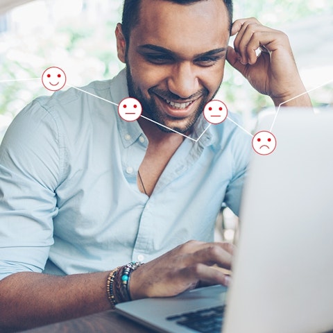 man working on laptop with downward trending bar graph line overlayed with emoji faces from smiling, neutral to sad along the line