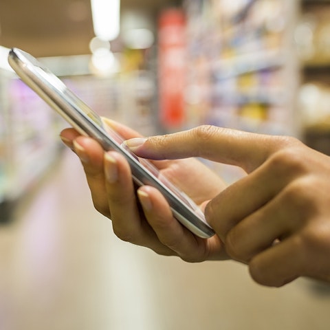 person in a store isle on a phone