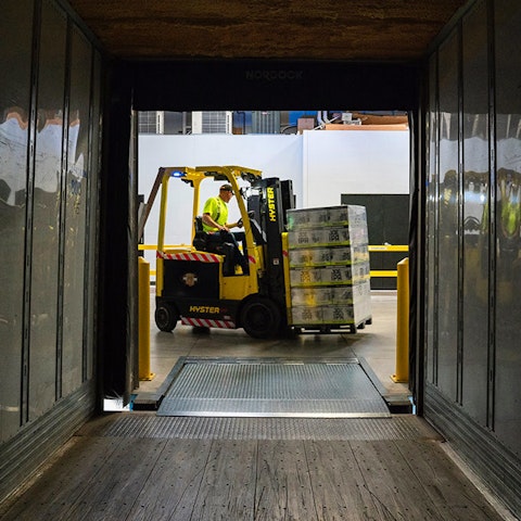 view from inside a truck trailer being unloaded by a forklift