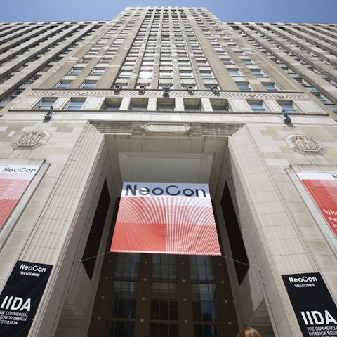 exterior front entry of a large sky scraper with a NeoCon banner hanging in the entrance